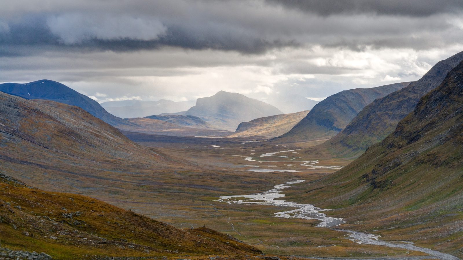 Kungsleden: the trail through the wide Tjäktjavagge valley below snowy peaks, between the Tjäktja pass and Sälka, Swedish Lapland