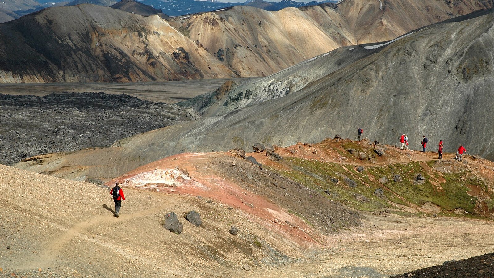 Laugavegur: hikers on the colourful rhyolite slopes of Brennisteinsalda above Landmannalaugar, Iceland